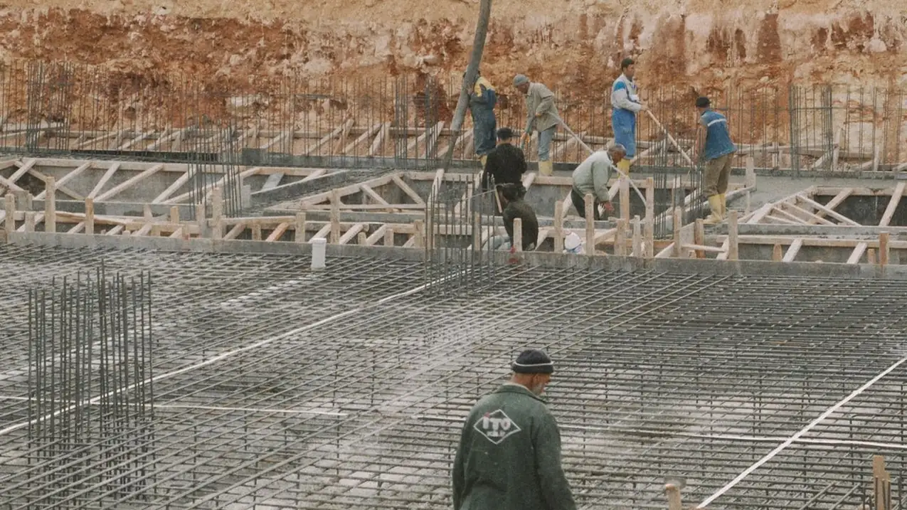 A large reinforcing steel mat tied out across a prepared foundation ahead of a concrete pour