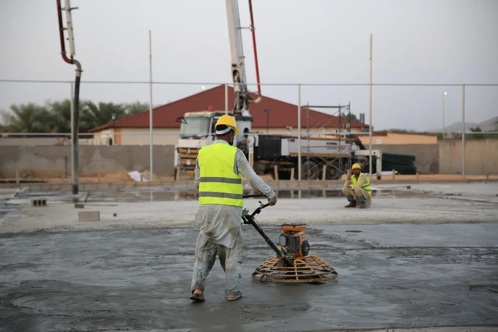 A power trowel finishing a narrow strip of freshly placed concrete