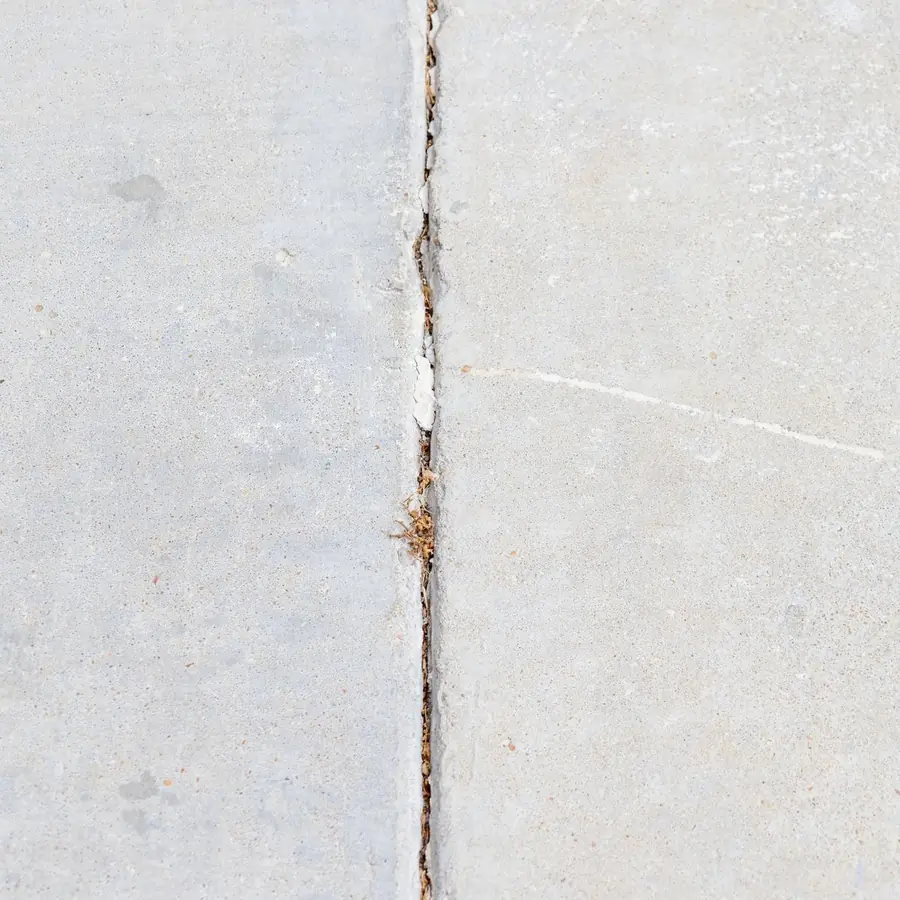 A single clean crack running across an aged concrete slab