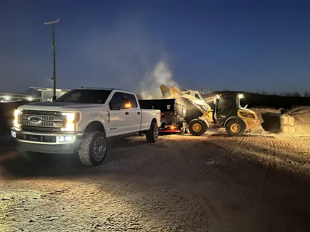 The work truck and loader on site at dusk