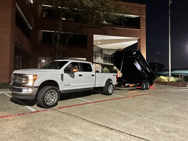 The work truck and dump trailer outside a commercial building