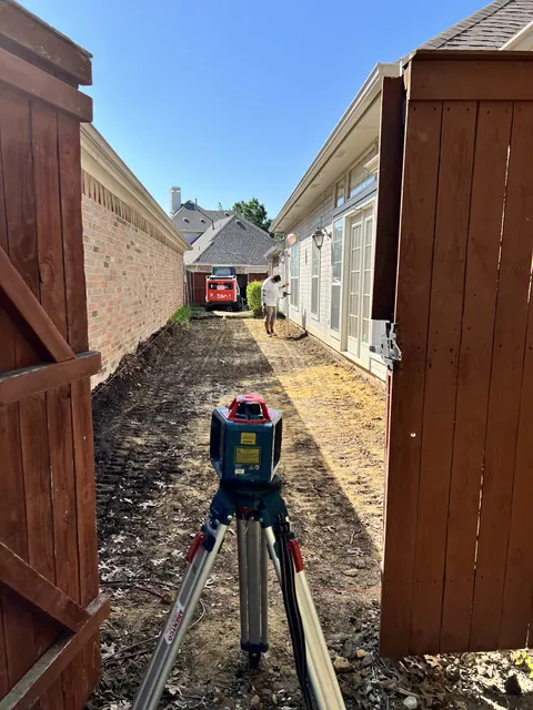 A laser level set up to grade a narrow side yard