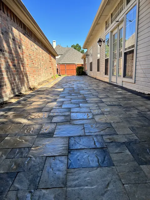 Stamped concrete in a dark slate pattern, still wet from sealing