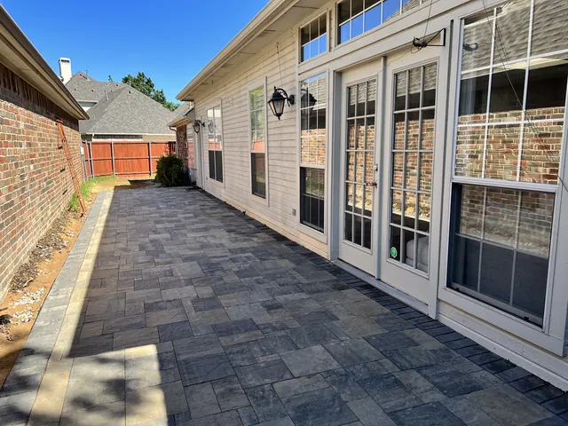 A stamped concrete walkway along a home's French doors