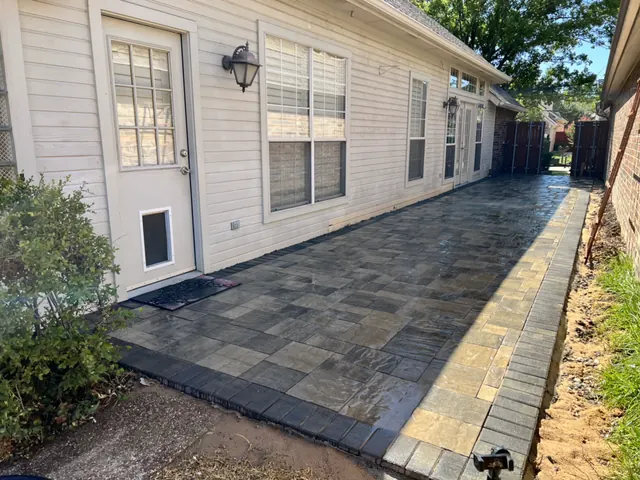 A finished paver walkway along the side of a home