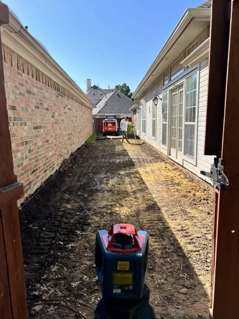 A side yard dug out and graded ahead of a pour