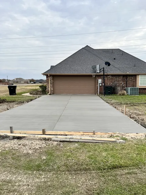 A finished concrete driveway leading up to a two-car garage