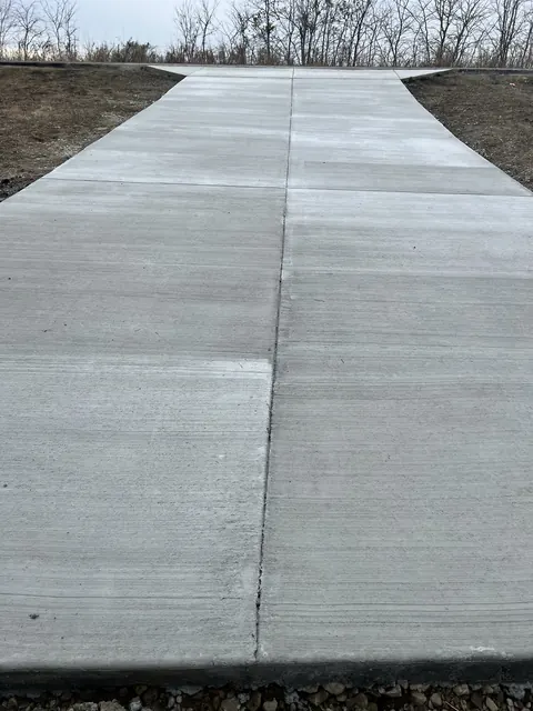 A finished concrete driveway apron with clean control joints