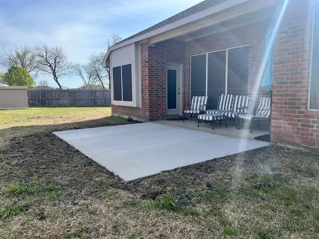 A new concrete patio extending a covered back porch