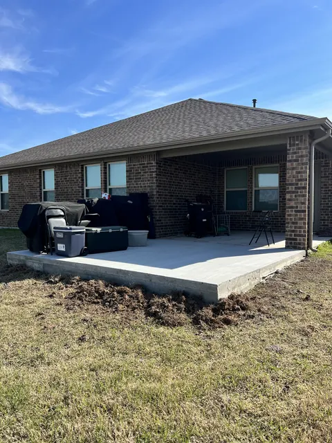 A finished concrete patio with a grill and outdoor kitchen area