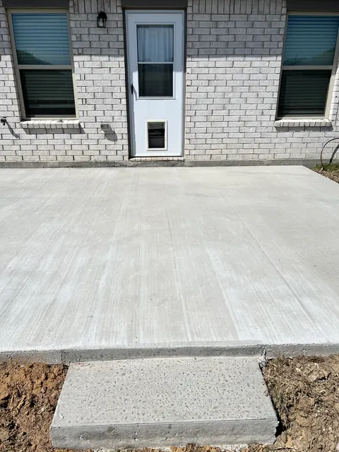 A finished concrete patio and step at a back door