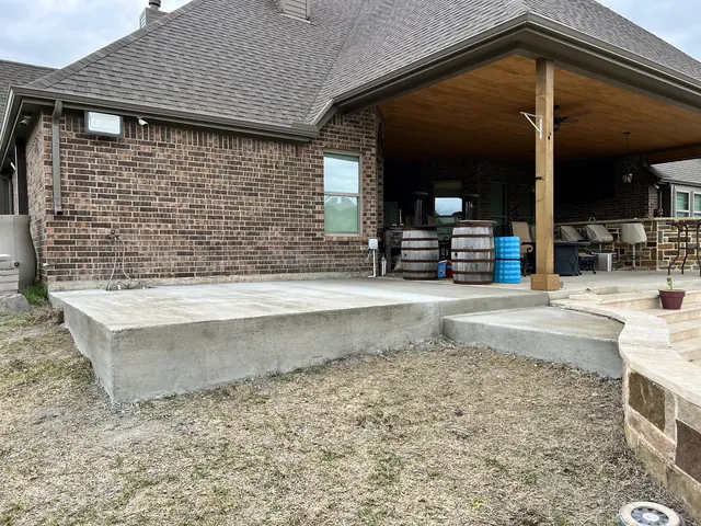 A raised concrete patio under a covered outdoor living area