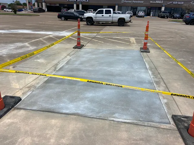 A replaced parking lot slab taped off with cones