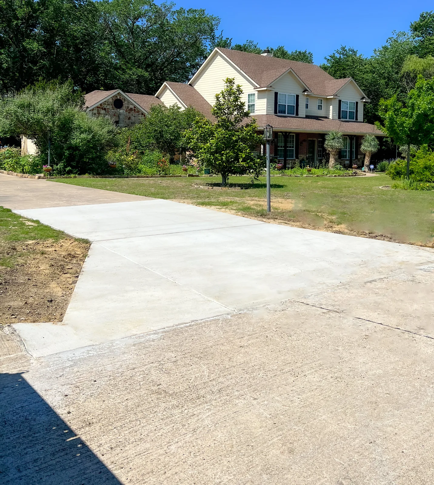 A wide finished concrete driveway at a two-storey home