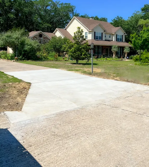 A wide finished concrete driveway at a two-storey home