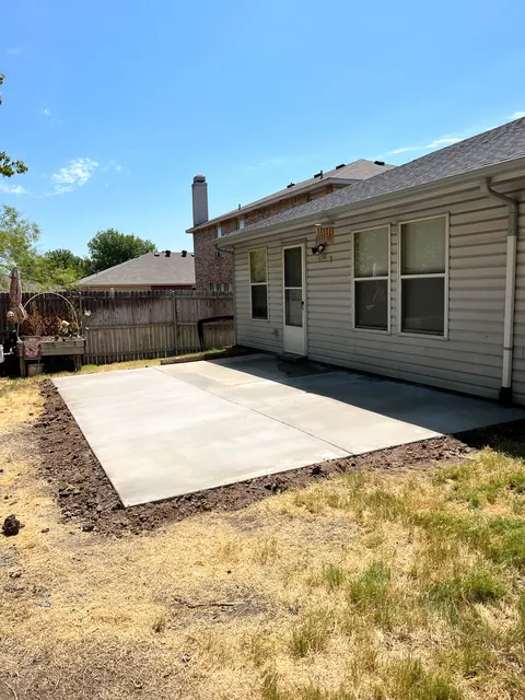 A finished concrete patio slab in a backyard