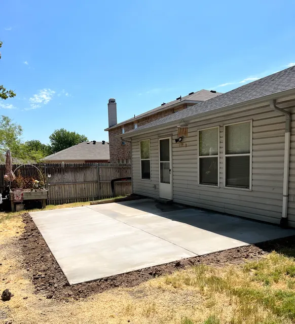 A new concrete patio laid along the back of a home
