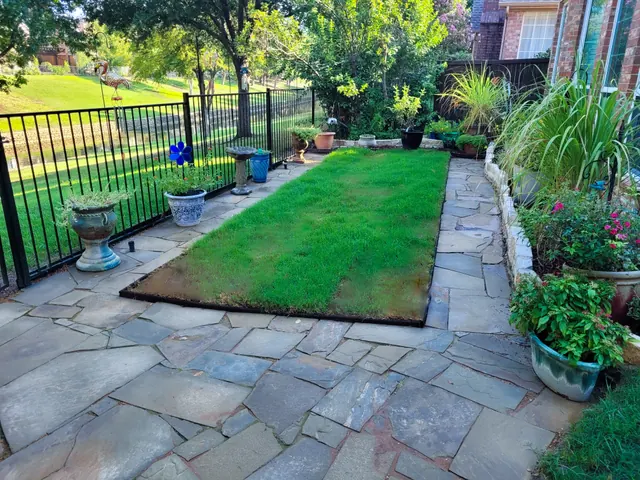 A flagstone patio wrapping around a lawn